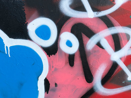 Graffiti-style spray paint artwork showing contrasting colors—blue, pink, red, black, and white—illustrating color layering, contrast, and visual balance.”